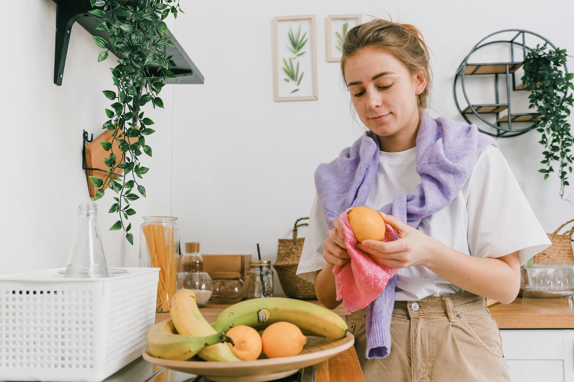 woman holding a lemon fruit near a counter